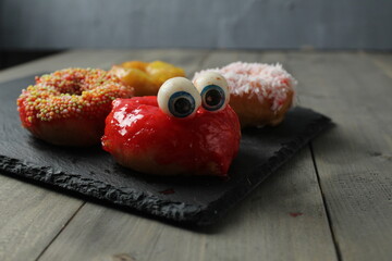 Ponchik donat with eyes on a gray background with space for copyspace text. Preparing for Halloween