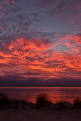 Fototapeta premium Dramatic glowing sunrise at a beach in Marahau, New Zealand