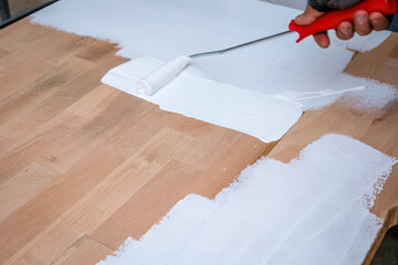 Painting and caring for wood with white paint. Brush in hand and painting wooden table. Renewing, Renovation Wooden Garden Furniture