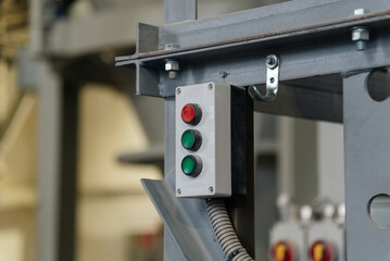 red and green buttons for turning on and off conveyor at factory