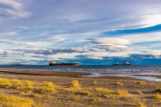 Punta Arenas city in Chile, Patagonia. Ships in port maritime old, ancient and modern ship in openair maritime museum Nao Victoria Museo. City on the sea and ocean shore strait of Magellan
