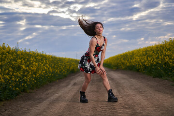 Fototapeta premium Beautiful woman in canola field
