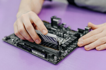 system administrator installing random access memory into motherboard, assembling PC of different...