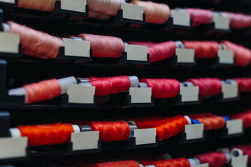 amount of different skeins of threads on special shelves in sewing studio or atelier, several...