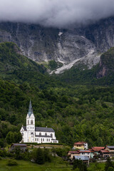 Fototapeta premium San Fermin Church immersed in the green of the Slovenian mountains a few steps from Caporetto. It remains a precious gem of Christianity and faith to be admired, makes the view of the mountain unique.