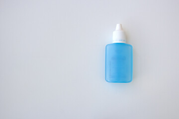 Blue medical squeezable plastic dropper bottle on white background with space for copy. Pharmaceutical, hospital, laboratory supplies.