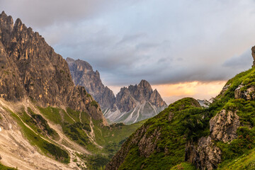 Dolomiti Alps beautiful mountain landscape. Rocky tower alpine summits in the Dolomites. Summer mountain scenic view on the hiking trekking path in the green mountain valley and blue sky with clouds