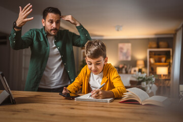 Fototapeta premium Angry father yell at his son to do homework as soon as possible