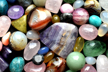 Background made of beautiful natural colored semi-precious stones. Purple fluorite, rose quartz and...