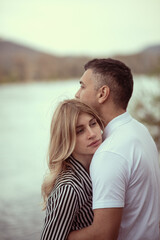 Naklejka premium Couple standing by the river, man hugging woman.