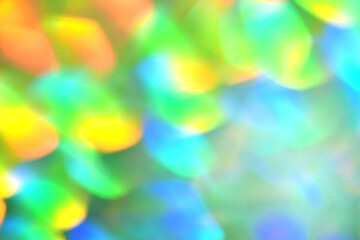 Rainbow background, blurred effect. Glowing holiday light circles are created from bokeh in the camera and lens. Background for design.