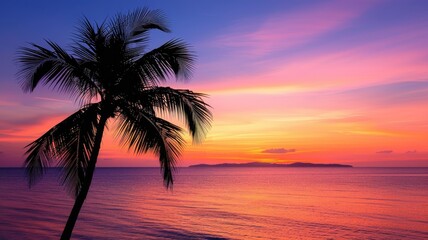 Tropical sunset over ocean with palm tree silhouette