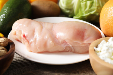 Healthy meal. Different vegetables and raw chicken breast on wooden table, closeup