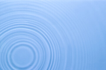 Rippled surface of clear water on light blue background, top view