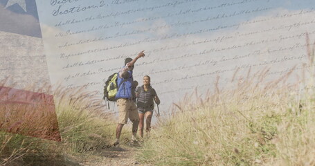 Image of american flag over diverse couple hiking in mountains