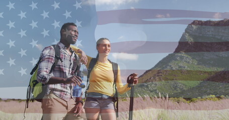 Image of independence day text over smiling diverse couple hiking