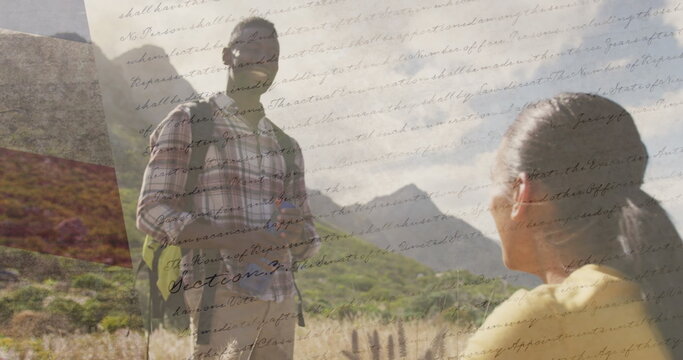 Image of american flag over smiling diverse couple hiking in mountains - Powered by Adobe