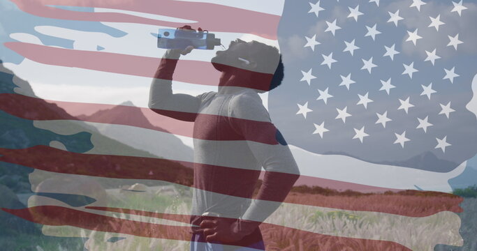 Image of american flag over african american man drinking water in mountains - Powered by Adobe