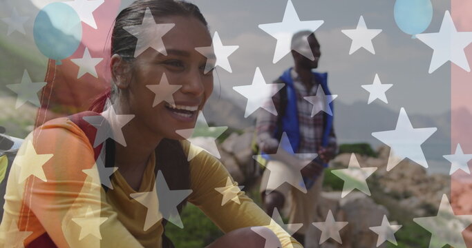 Image of american flag over smiling diverse couple hiking in mountains - Powered by Adobe