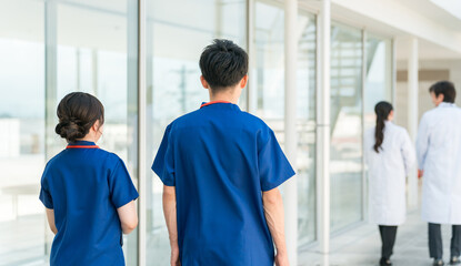 Obraz premium 病院の通路を歩く医者・医師・看護師・医療従事者・ドクター・作業療法士・理学療法士の男女 