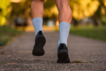 Close up of male athlete runner feet running on road, Jogging concept at outdoors. Man running for...