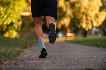 Close up of male athlete runner feet running on road, Jogging concept at outdoors. Man running for...