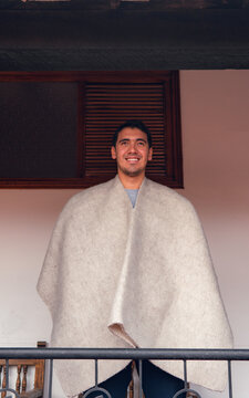 portrait latin man smiling wearing ruana looking at the horizon