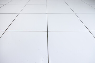 Tile floor under construction in perspective view by white square ceramic tile. Finishing material...