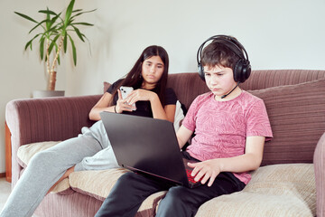 gamer boy playing on the couch with his sister in the living room of the house