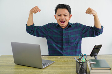 Strong young asian man sit work at wooden desk with pc laptop. Achievement business career...