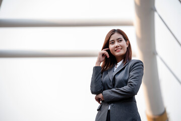 Portrait Businesswoman arms crossed smiling look at camera in modern city background. Happy...