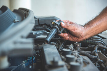 Close up Mechanic man hands repairing car auto repair shop uses jack change tyre. Man hands fixing...