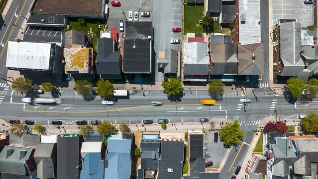 Traffic on Main Street in small American town. Aerial top down tracking hyper lapse, timelapse. Quaint USA town establishing drone shot.