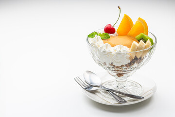 白背景にガラスの器にはいったプリンアラモードとコピースペース