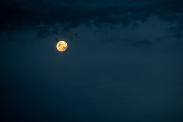 Serene Full Moon Illuminating the Night Sky with Dark Clouds Creating a Mystical Ambiance
