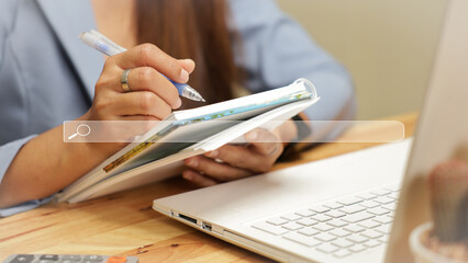A business woman uses her right hand to hold a pen and write down information in a notebook. Search learning concept For business and education