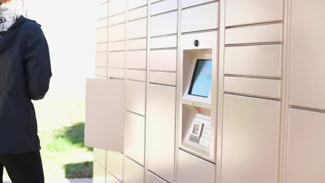 A woman retrieving a package from an outdoor package locker system, highlighting convenient parcel pickup