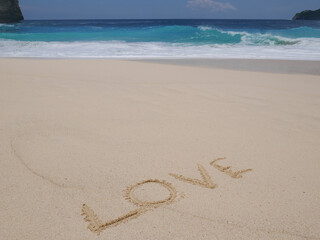 Love Symbol On a Sand Of Beach With Soft Blue Wave On Background