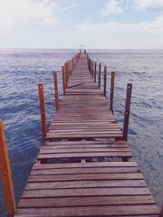Obraz premium Wooden bridge on the tropical beach and blue sky summer background