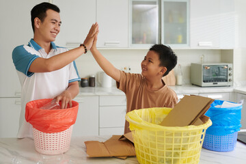 Father and son giving high five after sorting waste