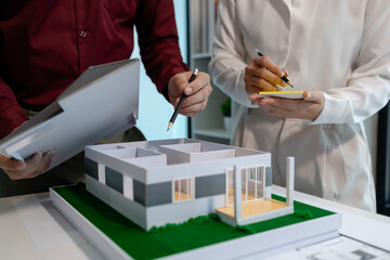 two architects are discussing about new project of the biggest housing estate company who hire...