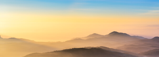 Mountain range panorama in sunrise sky, mountain ridge in sunlight.