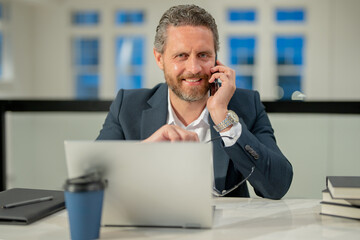 Office worker with laptop at office. Ofice employee remote working in modern office. Businessman have on line meeting. Business man talking on phone at office workplace.