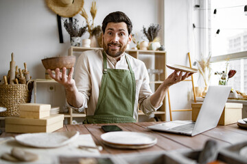 Concept of online trade and retail in pottery shop. Portrait of mature man does not know which item...