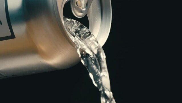 White wine or clear liquid pouring out of silver can in super slow motion, black background of canned drink at 4k 800fps