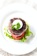 Tasty hamburger with tomatoes and onion. Bright wooden background. Top view.