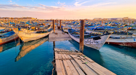 Colorful fishing boats docked at Nouadhibou Harbor at sunset