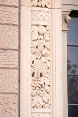 Vintage elegant door frame details, ornated with fruits and cereals. Located at an eclectic building facade.