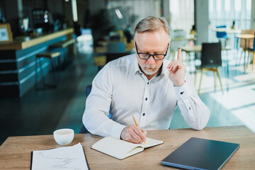 Mature businessman working while sitting in the office. A middle-aged executive is working in the...