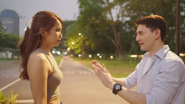 Frustrated girlfriend slapping on boyfriend after he trying hard to reconcile from big arguing while spending time on date together on weekend inside park. Lover fight in public. Married Life Problem